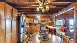 L’intérieur d’une cabane en bois comprend un coin repas, une cuisine et un espace de vie.