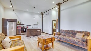 Een moderne woonruimte met keuken, eethoek en zithoek.