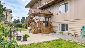 A wooden deck with a staircase leading to a balcony, outdoor furniture, and potted plants. - Anchorage Apartment Rental w/ Mountain Views! (Anchorage)