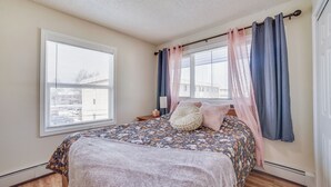 A bedroom with a bed, two windows, a nightstand, and a lamp. - Quiet Anchorage Retreat, 4 Mi to Earthquake Park (Anchorage)