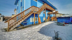 A two-story blue house with a wooden staircase leading to a balcony. - Quiet Anchorage Retreat, 4 Mi to Earthquake Park (Anchorage)