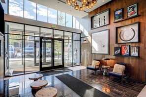 A hotel lobby with a glass entrance, a reception desk, and a seating area with a coffee table. - Ski-in/ski-out Resort Studio w/ Views in Park City (Park City)