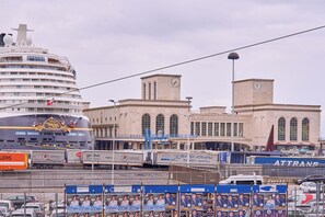 A cruise ship docked at a port with a large building in the background. - La Marina (Naples)