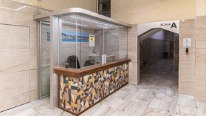 A reception area with a glass partition, a patterned counter, and a sign reading "SCALA A". - La Marina (Naples)