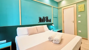 A hotel room with a bed, a wall-mounted artwork, a door, and a nightstand. - La Marina (Naples)