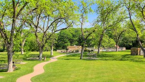 A park with a curved pathway, benches, and trees.