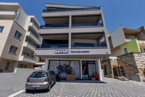 En bygning med flere etager, med et skilt der viser 'KOTAC Partner Vaešy Automobile'.