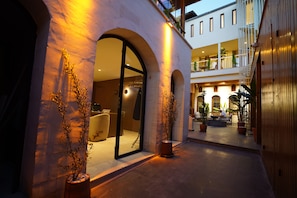 A modern building with a glass entrance, outdoor seating, and potted plants. - Gülten Hanım Konağı (Gaziantep)