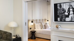 Un salon moderne avec une cheminée, un canapé, une lampe et un tableau encadré au mur.