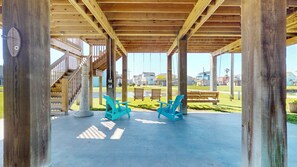 Un pabellón de madera con piso de concreto, una escalera y dos columpios.