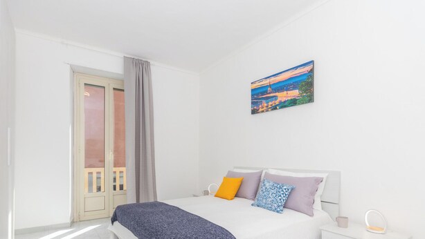 A modern bedroom with a bed, bedside table, and a painting on the wall. - Casa Delia by Wonderful Italy (Torino)