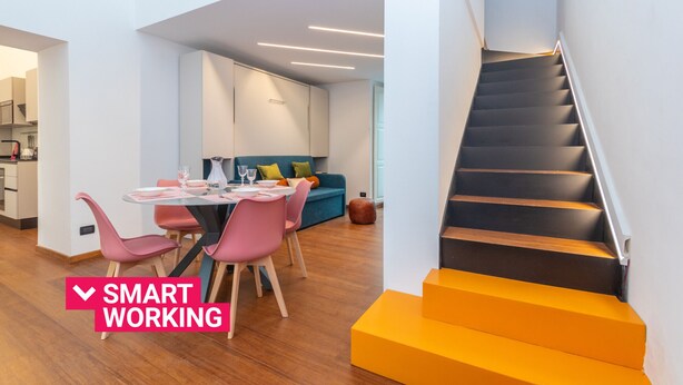 Ein modernes Interieur mit Essbereich, Treppe und Küche.