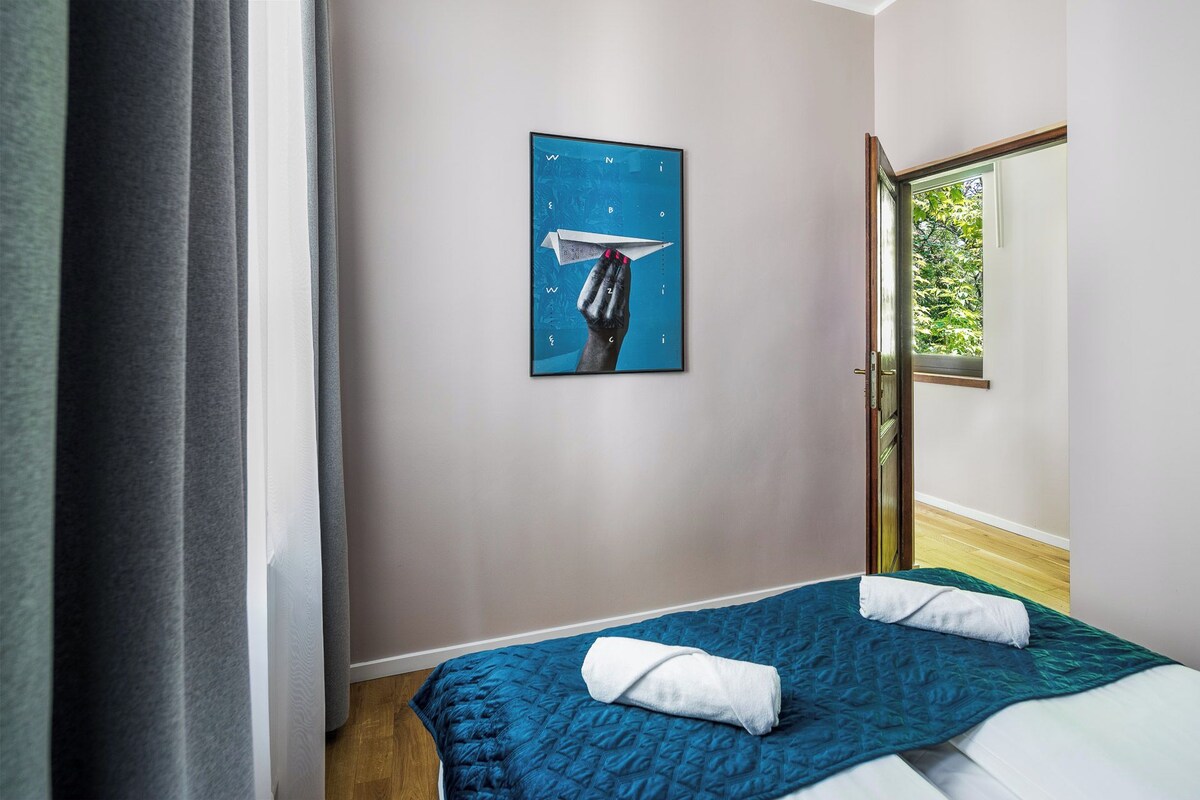 Un dormitorio con cama, un cuadro y una ventana.