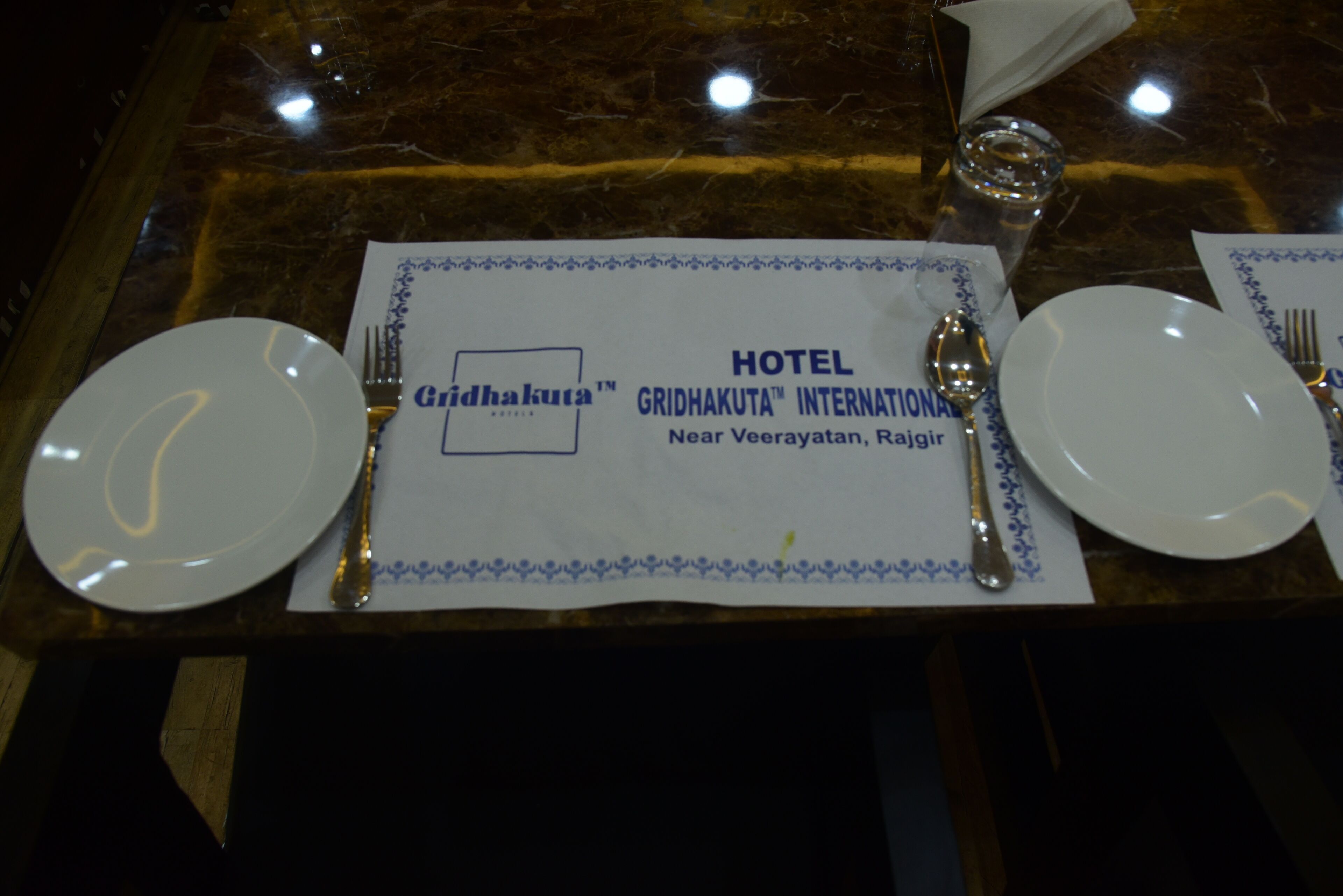 Un montaje de mesa de hotel con un posavasos que muestra el nombre y la ubicación del hotel.