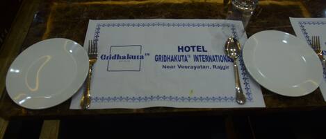 Un montaje de mesa de hotel con un posavasos que muestra el nombre y la ubicación del hotel.