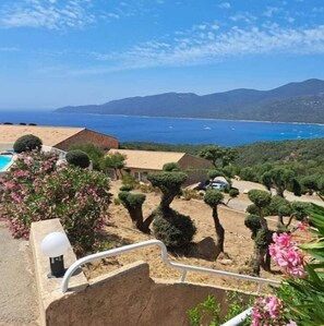 Enjoy breathtaking views of the sea and distant mountains from this serene coastal property, surrounded by a beautifully maintained garden and a swimming pool.