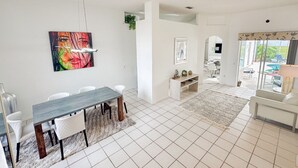 Een moderne woonkamer met een eethoek, een televisie en uitzicht op het omliggende landschap.