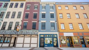 A row of colorful buildings with distinct architectural styles, including a blue storefront with a large glass window.