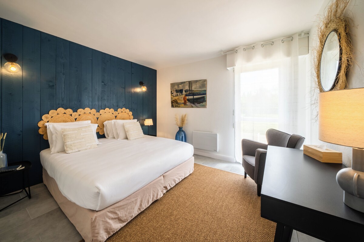 Une chambre moderne avec un grand lit, un bureau et une chaise.