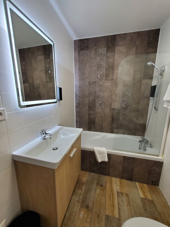 A bathroom with a double sink, a bathtub, and a shower. - Hôtel de la Brière et Restaurant Les Krapados (Saint-Lyphard)