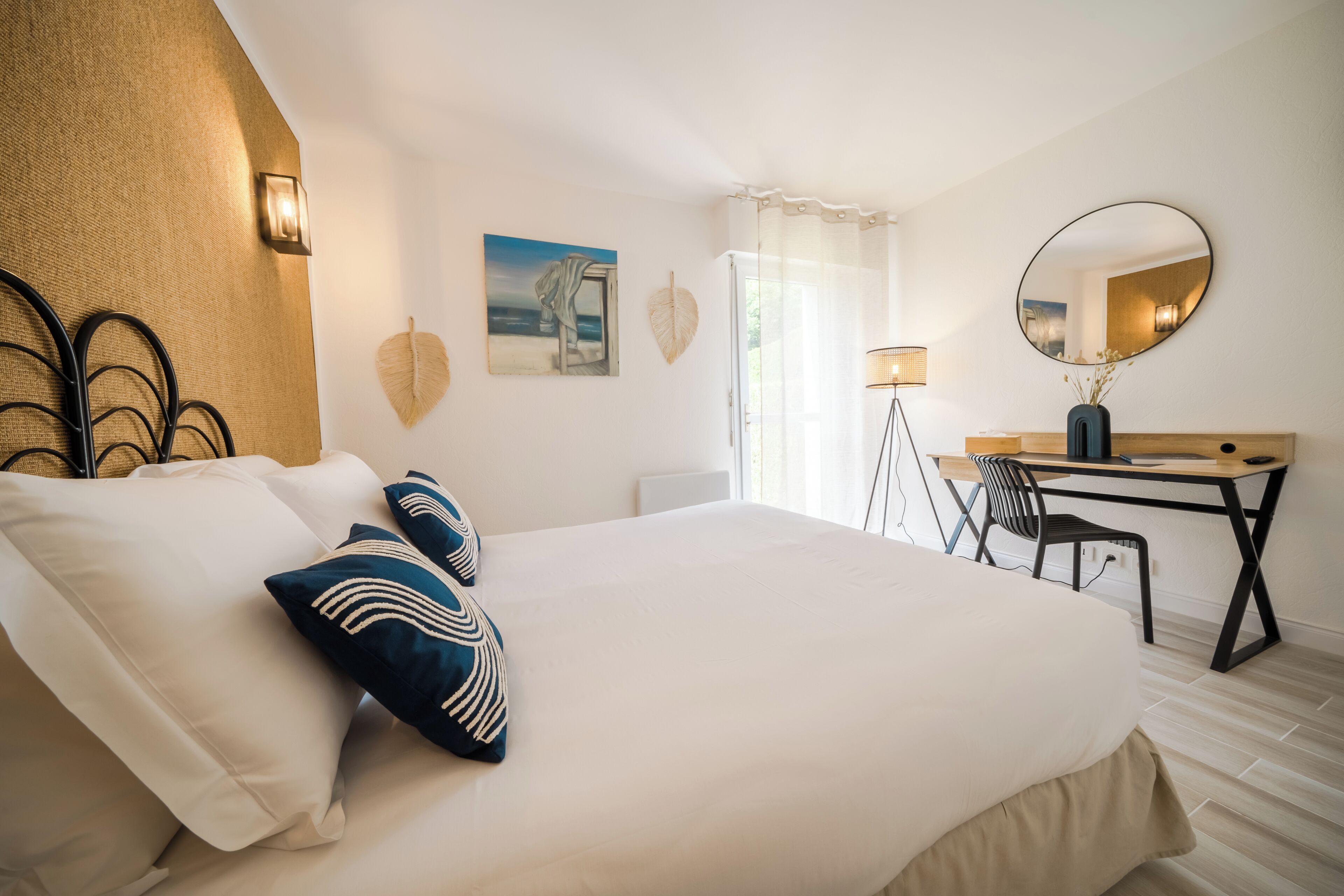 Un dormitorio ordenado con una cama grande, un escritorio y una silla.