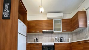 A kitchen with wooden cabinets, a white refrigerator, a stove, and a coffee maker.