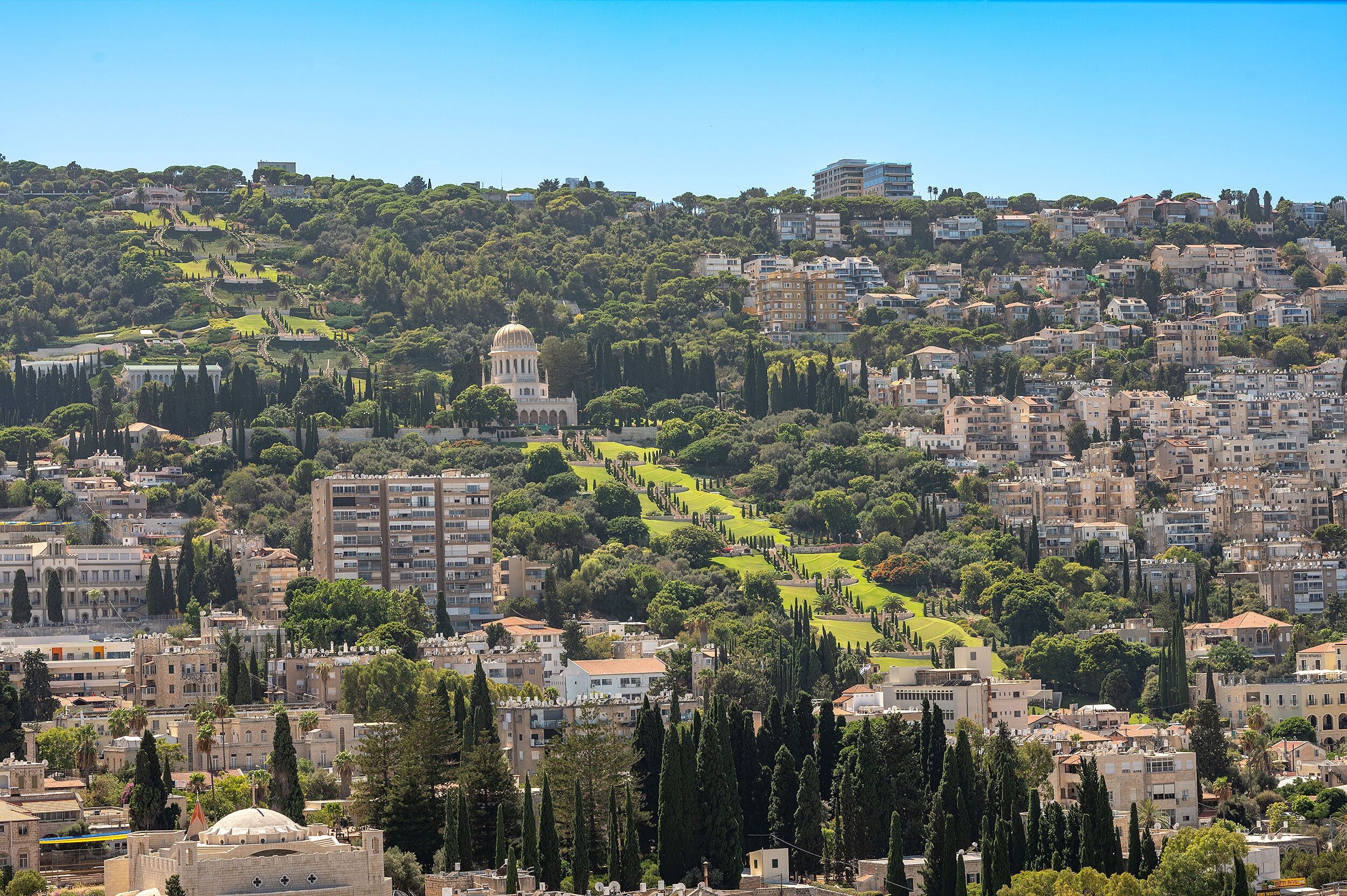 Un paysage urbain caractérisé par un dôme imposant, des immeubles résidentiels denses et un vaste espace vert aménagé en parc.
