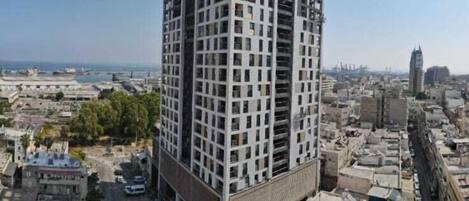 Un edificio de gran altura con diseño moderno, que cuenta con varios balcones y un patio central.
