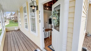 A house with a porch, a welcome sign, and a number 710 on the door. - Adorable Little Yellow House, Prime Location! Downtown Pella, IA (Pella)