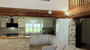 Una cocina moderna con una isla de piedra, un sofá blanco y un cuadro grande con ciervos en la pared.