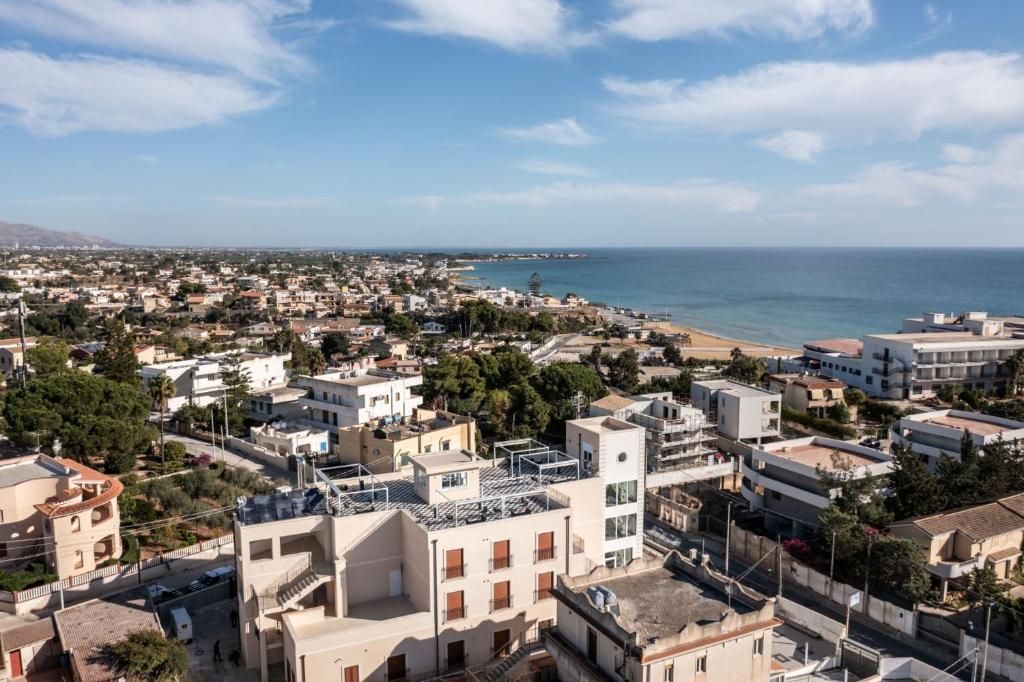 A coastal town with buildings, a beach, and a clear sky.