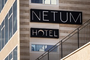 Un letrero de hotel con el nombre 'NETUM HOTEL' en la fachada de un edificio.