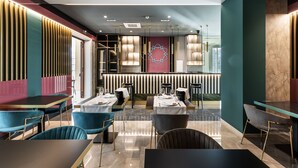 Un restaurante moderno con diversas opciones de asientos, incluyendo mesas y cabinas, y una zona de bar central.