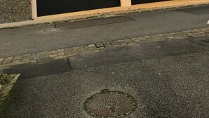En moderne bygning med en stenfassade, to garageporte og et skråt tag.