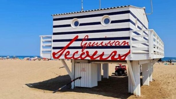 Une tour de surveillance, portant le nom « Hans van Seijen », est située sur une plage de sable.