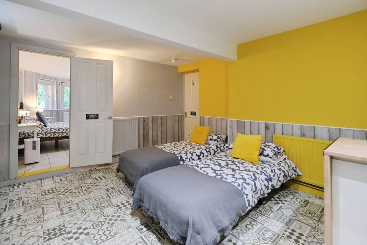 A bedroom with a bed, two bedside tables, a mirror, and a radiator.