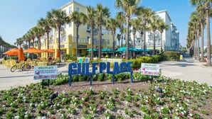 A sign for a wine walkabout event at a coastal location with palm trees and outdoor seating. - Gulf View! Pool, Tennis Court, Beach Access (Santa Rosa Beach)