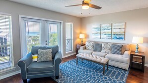 A living room with a blue patterned rug, two sofas, a coffee table, and a ceiling fan. - Gulf View! Pool, Tennis Court, Beach Access (Santa Rosa Beach)