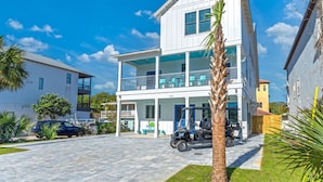 A two-story building with a balcony, a golf cart, and a car parked in front. - Mariner: New! Private Beach! (Miramar Beach)