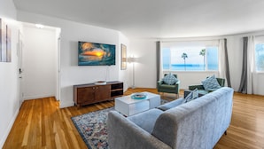 A modern living room with a sofa, coffee table, and artwork on the wall. - Ocean Front Across From Beach/Amazing Views (La Jolla)