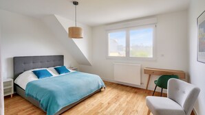 Ein Schlafzimmer mit einem Bett, einem Schreibtisch und einem Stuhl.