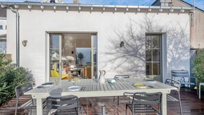 An outdoor patio with a table set for dining, surrounded by metal chairs. - Renovated house for 7 with garden, near beach (Batz-sur-Mer)