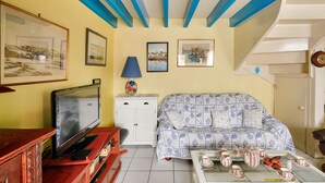 A living room with a television, sofa, coffee table, and framed pictures on the wall. - 250m from the beach, house for 6, Île Tudy (Ile Tudy)
