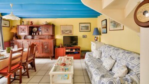 A living room with a dining area, a television, and a sofa. - 250m from the beach, house for 6, Île Tudy (Ile Tudy)