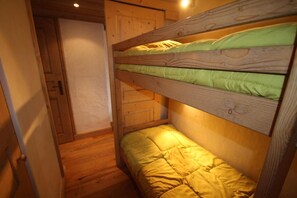 Una cama litera con cabeceras de madera y un colchón verde.