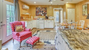 A cozy cabin interior with a dining area, kitchen, and a red plaid chair. - Tranquil Fairmont Studio w/ Patios - Pets Welcome! (Fairmont)