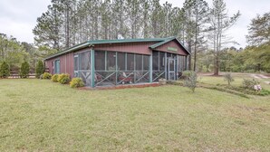 A rustic cabin with a large porch and a covered outdoor seating area. - Tranquil Fairmont Studio w/ Patios - Pets Welcome! (Fairmont)