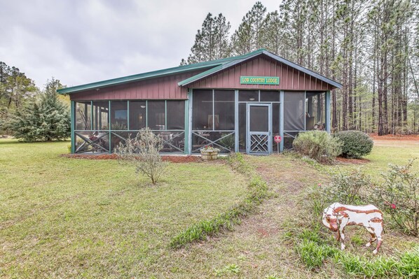 Eine Lodge mit überdachter Veranda und einem Schild mit der Aufschrift "LOW COUNTRY LODGE".