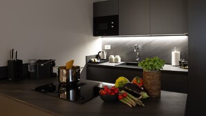 A modern kitchen with a built-in stove, a sink, and a flat-screen TV above the countertop.