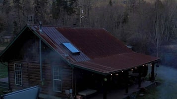 Eine Blockhütte mit Whirlpool, Sitzgelegenheit im Freien und Kamin.